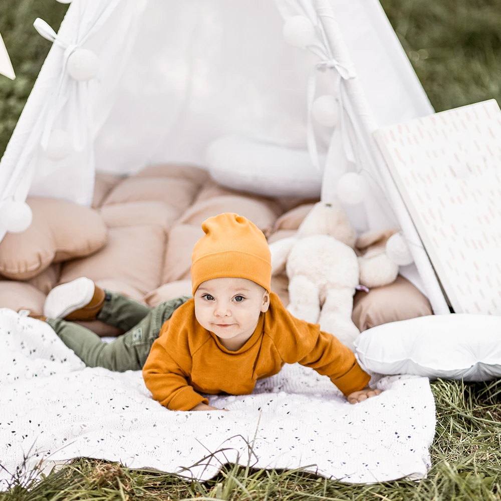 Baby liegt draussen mit huebsches und nachhaltiges kleidung