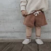 Baby trägt Shorts Alda Braun 9