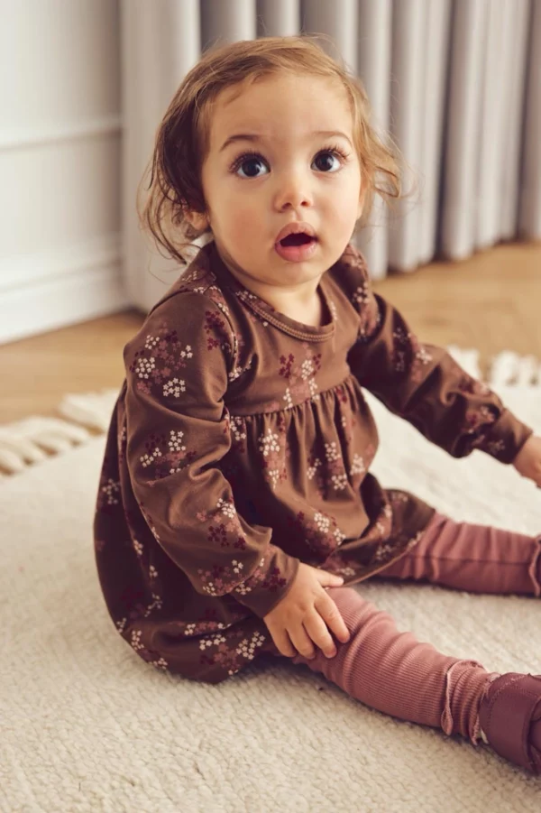 Baby trägt Kleid Liora Braun 1