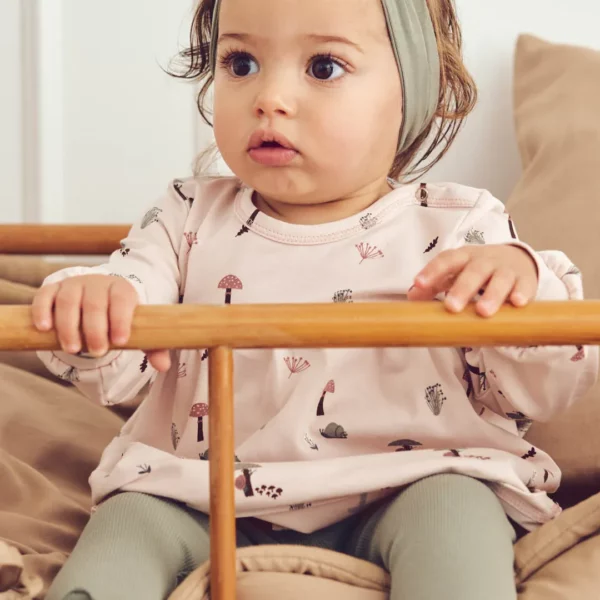 Baby trägt Kleid Mila Rosa 1